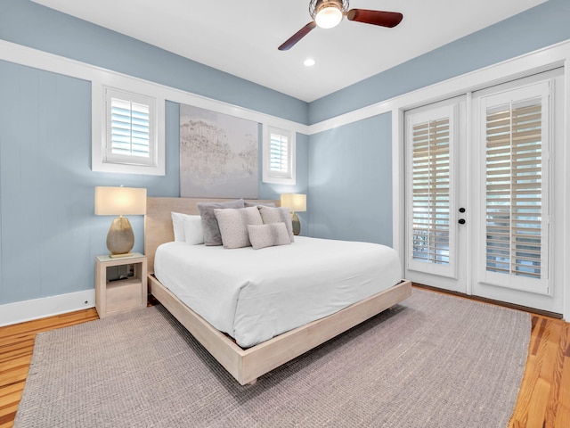 bedroom featuring access to exterior, multiple windows, wood-type flooring, and ceiling fan