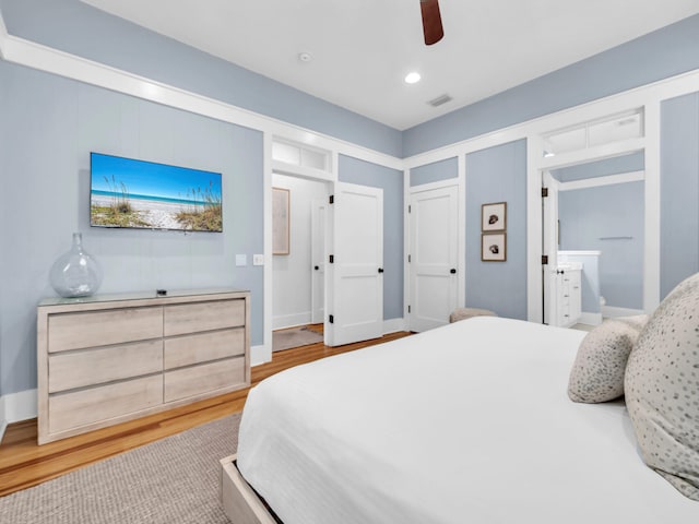 bedroom featuring ensuite bath, light wood-type flooring, and ceiling fan