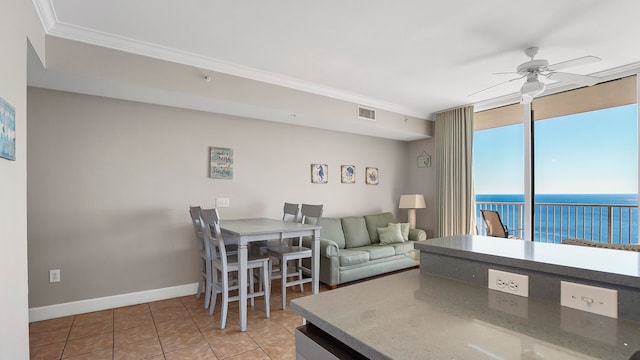 tiled living room featuring a water view, ceiling fan, and ornamental molding