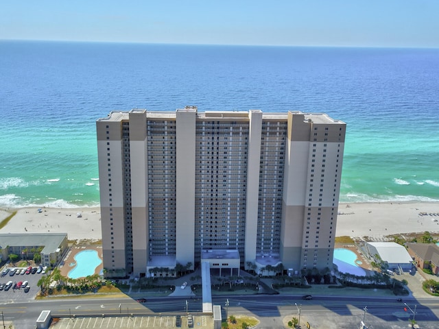 drone / aerial view featuring a water view and a beach view