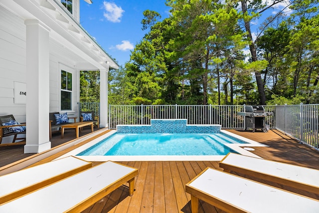 view of swimming pool featuring area for grilling and a deck