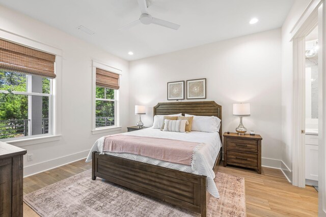 bedroom with ensuite bath, light wood-type flooring, and ceiling fan