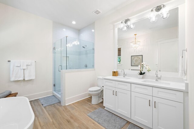 full bathroom with hardwood / wood-style flooring, independent shower and bath, toilet, vanity, and a notable chandelier