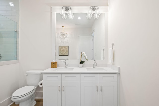 bathroom featuring toilet, walk in shower, vanity, and a chandelier