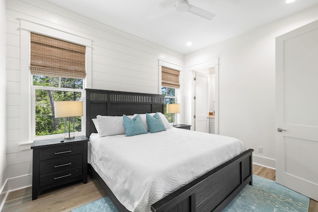 bedroom featuring multiple windows, light wood-type flooring, and ceiling fan