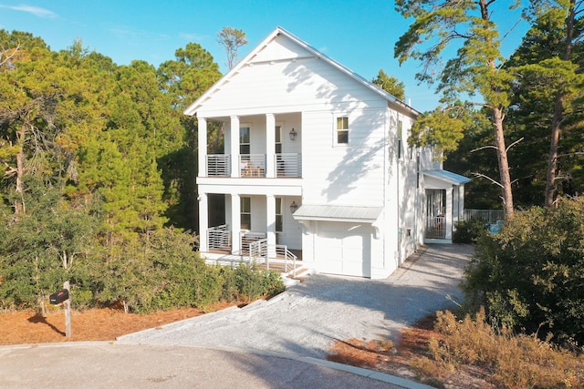 greek revival inspired property with a balcony and a garage