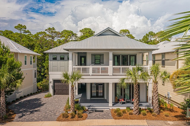 view of front of property with a balcony, covered porch, and a garage