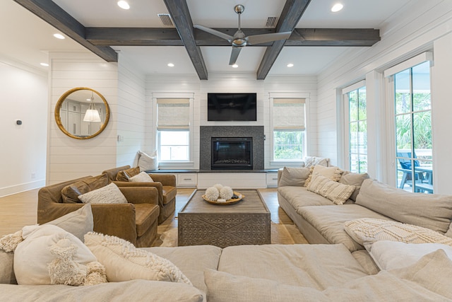 living room featuring wood walls, coffered ceiling, hardwood / wood-style flooring, beam ceiling, and ceiling fan