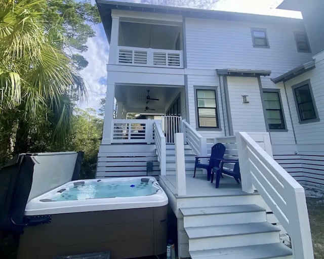 rear view of house featuring a hot tub, a deck, and ceiling fan