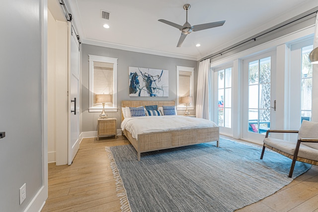 bedroom featuring ceiling fan, access to outside, a barn door, light wood-type flooring, and crown molding