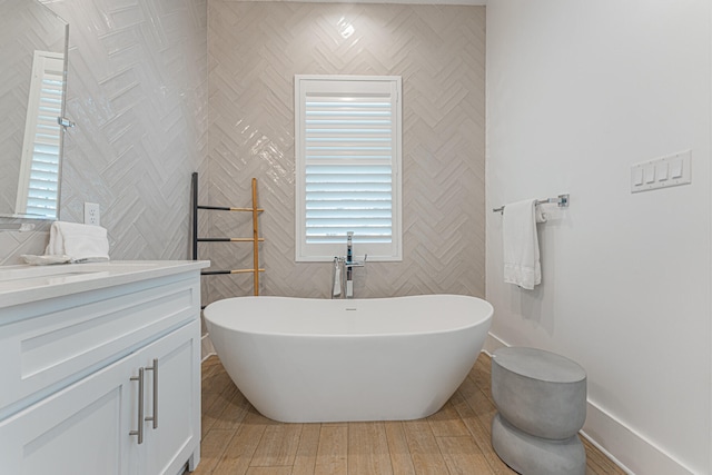 bathroom with vanity, a tub to relax in, and hardwood / wood-style floors