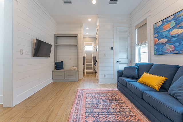 living room with ornamental molding and light hardwood / wood-style floors