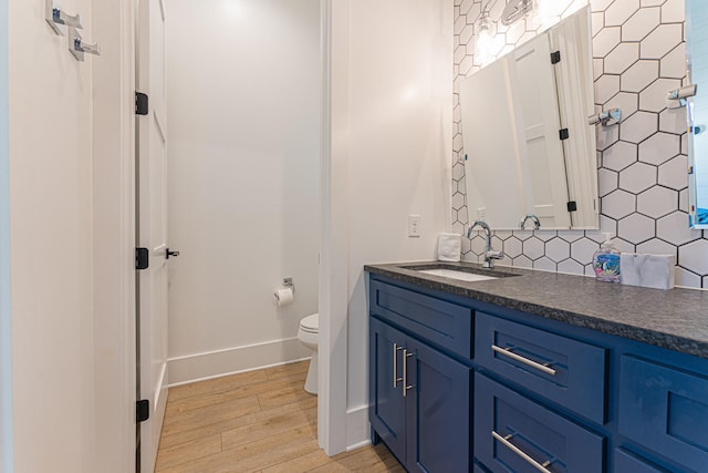 bathroom featuring toilet, tasteful backsplash, vanity, and wood-type flooring