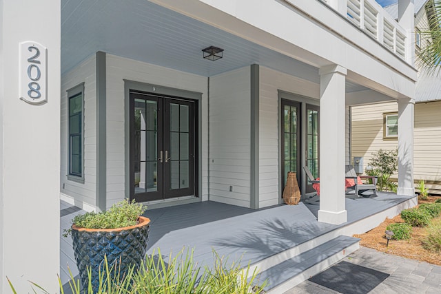 view of exterior entry with a porch and french doors