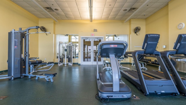 exercise room with a high ceiling and a drop ceiling