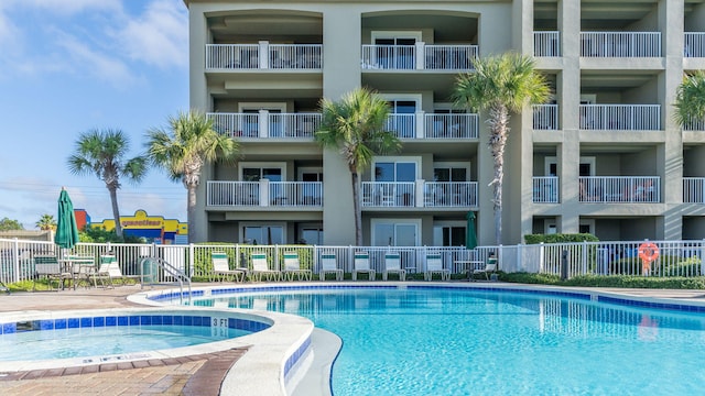 view of swimming pool with a hot tub