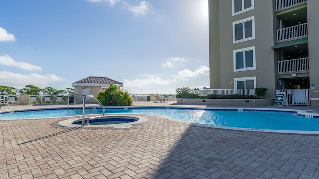 view of swimming pool with a hot tub and a patio