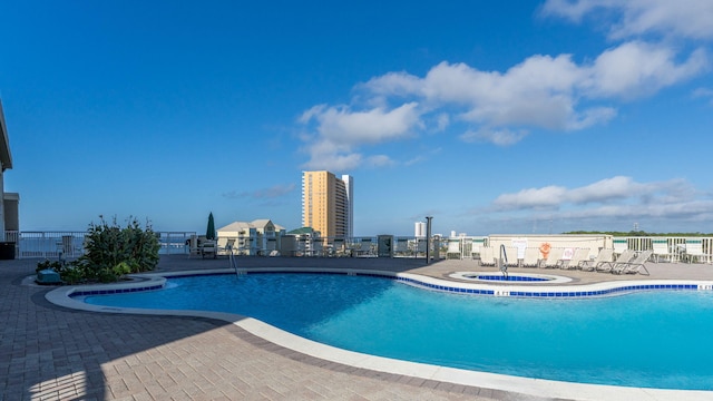 view of pool with a hot tub and a patio area