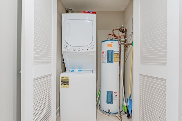 clothes washing area with electric water heater, light tile patterned floors, and stacked washer / dryer