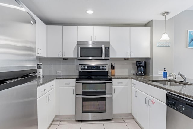 kitchen featuring white cabinetry, appliances with stainless steel finishes, sink, and light tile patterned floors