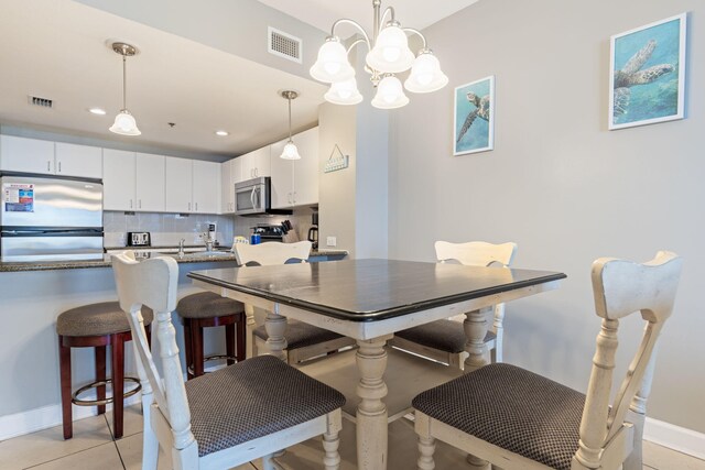 tiled dining area with an inviting chandelier