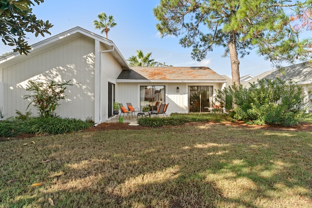 back of property featuring a lawn and a patio area