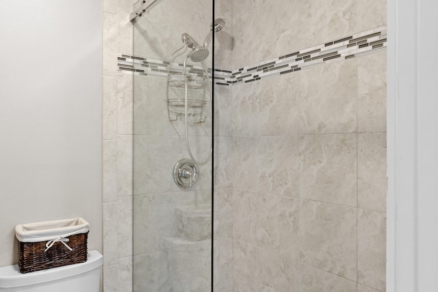 bathroom featuring tiled shower and toilet