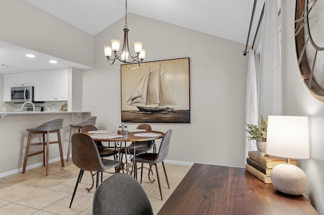 dining room with lofted ceiling, light tile patterned floors, and a chandelier