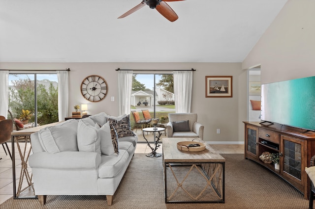 living room with plenty of natural light, ceiling fan, light tile patterned floors, and vaulted ceiling