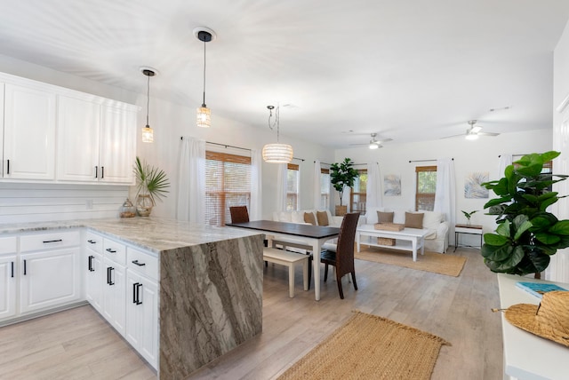 kitchen with white cabinetry, kitchen peninsula, and light hardwood / wood-style flooring