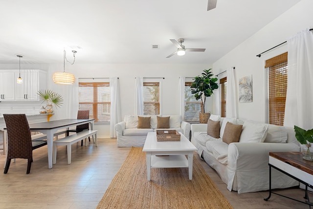 living room with ceiling fan and light hardwood / wood-style floors