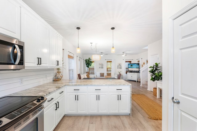 kitchen with white cabinets, kitchen peninsula, light hardwood / wood-style flooring, appliances with stainless steel finishes, and decorative light fixtures