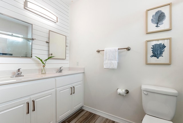 bathroom with toilet, vanity, and hardwood / wood-style floors