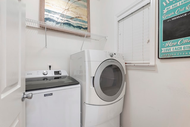 clothes washing area with separate washer and dryer