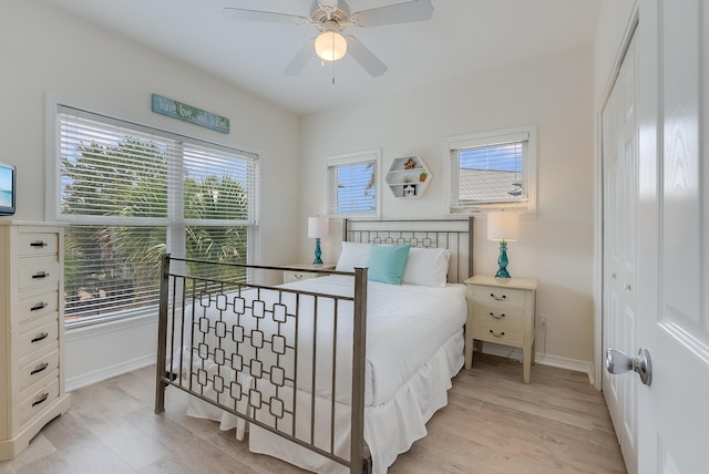 bedroom with ceiling fan, multiple windows, and light wood-type flooring