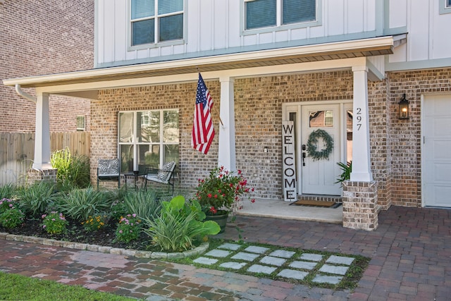 doorway to property featuring covered porch and a garage