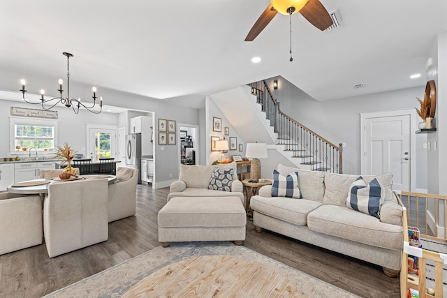 living room featuring light hardwood / wood-style floors, sink, and ceiling fan with notable chandelier