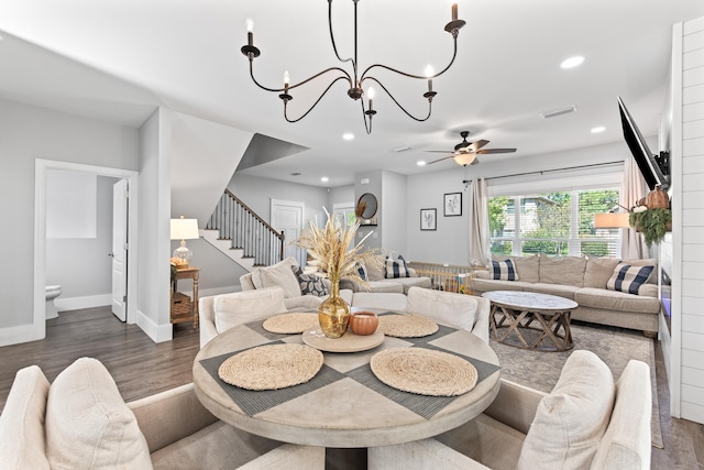 dining room featuring ceiling fan with notable chandelier and dark hardwood / wood-style floors