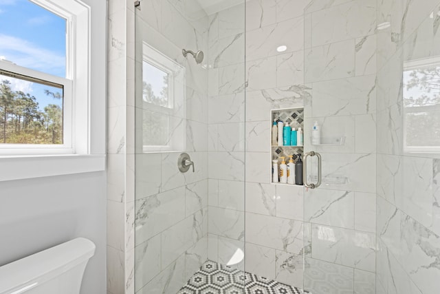 bathroom featuring toilet and an enclosed shower