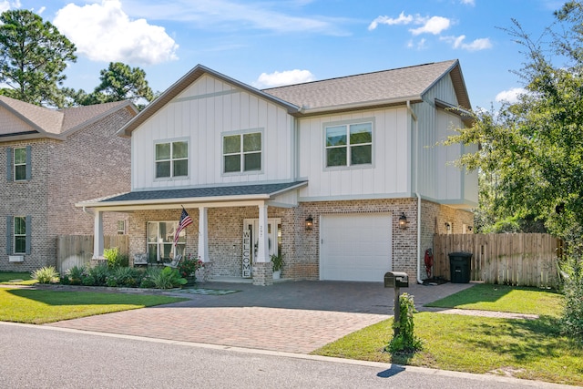 view of front facade featuring a porch, a front lawn, and a garage