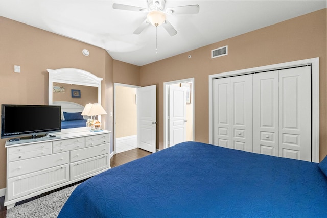 bedroom with a closet, dark hardwood / wood-style floors, and ceiling fan