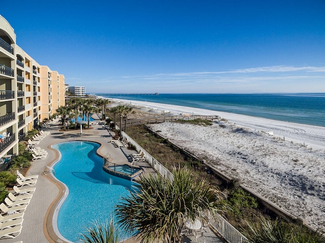 view of pool with a water view, a view of the beach, and a patio