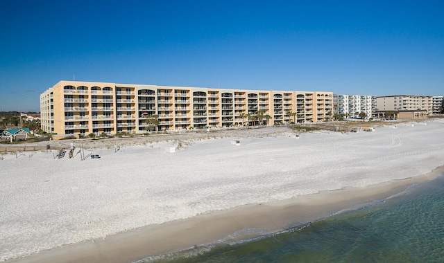 view of building exterior with a view of the beach and a water view