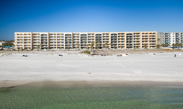 view of property featuring a water view and a beach view