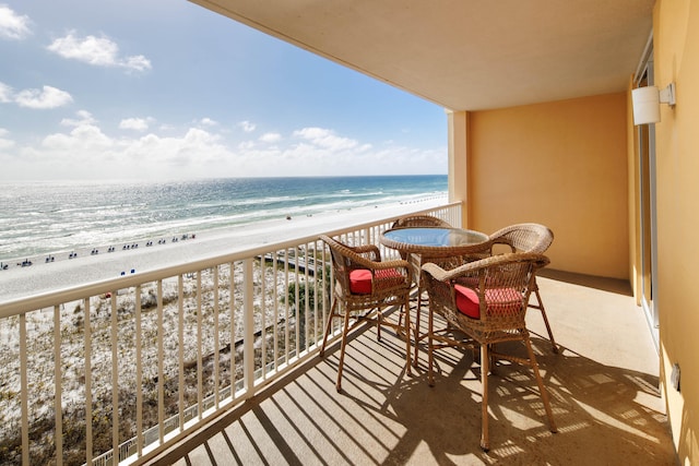 balcony with a water view and a view of the beach