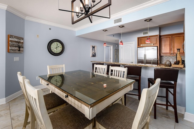 tiled dining room with a notable chandelier, sink, and crown molding