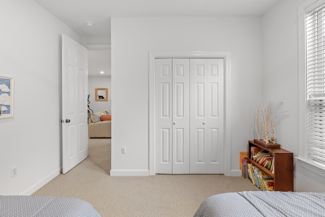 bedroom featuring a closet and light carpet