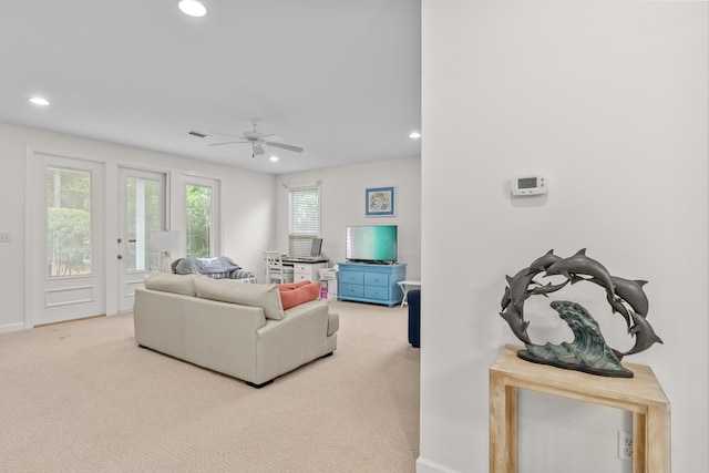 carpeted living room with ceiling fan