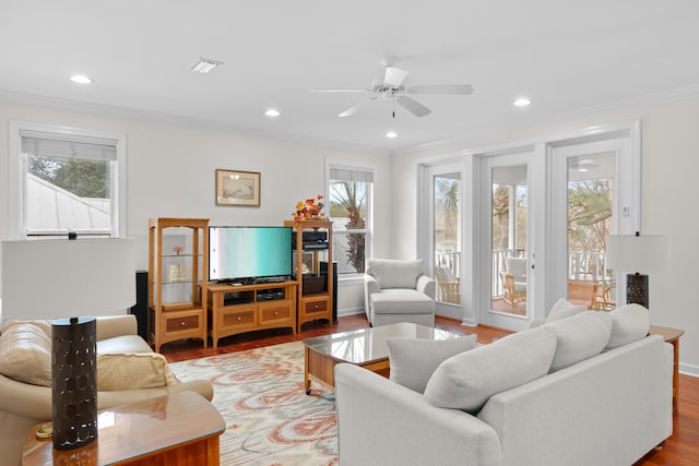 living room with ornamental molding, ceiling fan, and light hardwood / wood-style flooring