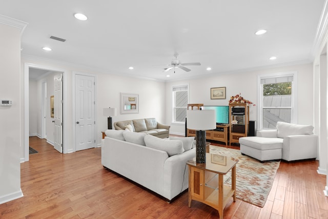 living room featuring light hardwood / wood-style floors, ceiling fan, and crown molding